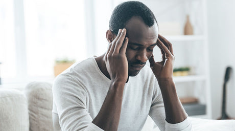 Man holding his head in his hands as he has a migraine.